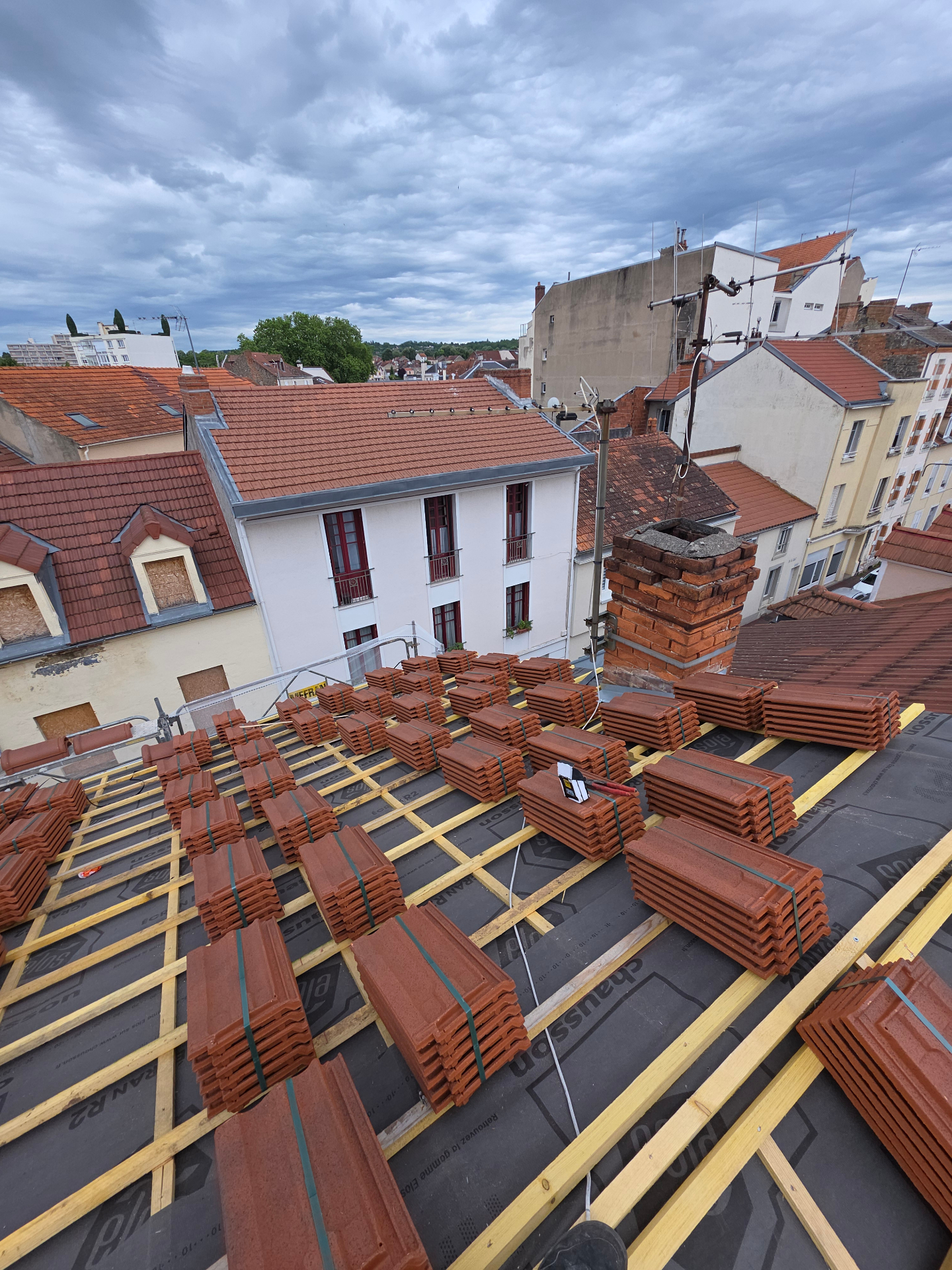 Pose de tuiles sur toiture en cours